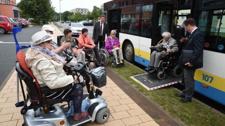Trainingsstunde vor dem Haus der Begegnung: Rollstuhl- und E- Scooter-Fahrer üben das Hineinfahren in den Bus.  