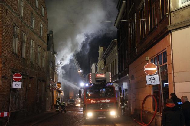 Feuerwehren bei Großbrand in Güstrower Innenstadt gefordert: Mehrzweckgebäude brennt - Flammen greifen auf Wohnhaus über - fünf Bewohner in Sicherheit gebracht - Polizei ermittelt wegen schwerer Brandstiftung