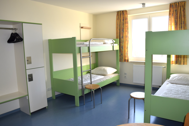 In einer weiteren Etage sind die Betten grün, der Fußboden blau und die Wände in einem Gelbton gehalten. Die Schränke sind neu gebaut und ähneln jetzt denen in anderen Jugendherbergen. 