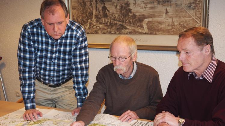 Roland Dilchert (v. l.), Hans Ewers und Helmut Dürnberg beugen sich über die Karte, die das neue Vorranggebiet für Windenergie ausweist.