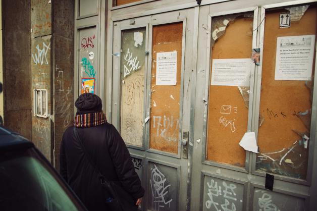 Die Mitgründerin des Vereins „Zeit-Geschichte(n) e.V.“, Heidi Bohley, steht vor der verschlossenen Eingangstür der ehemaligen Poliklinik Mitte in Halle(Saale).