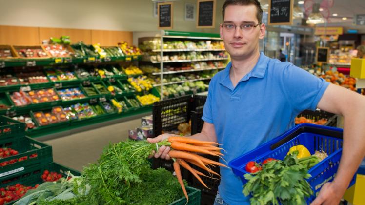 Der ehemalige Fleischer Hendrik Zühlke, der jetzt überzeugter Veganer ist, steht mit einem Einkaufskorb voller Gemüse in einem Supermarkt im brandenburgischen Schöneiche bei Berlin.