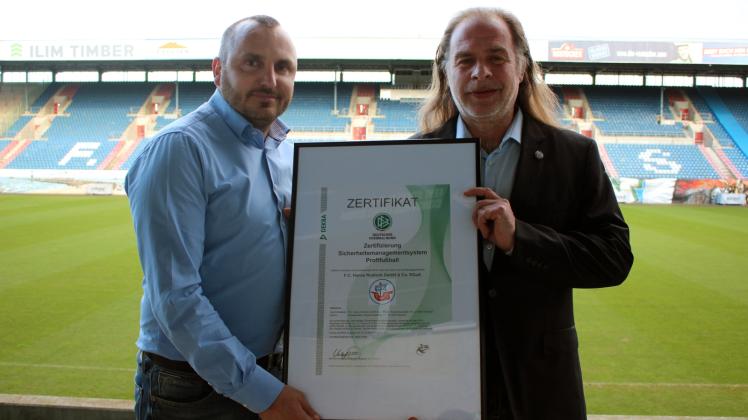 Vorstands-Chef Robert Marien (l.) und Veranstaltungsleiter Rainer Friedrich mit dem Zertifikat  „Sicherheitsmanagement im Profifußball“, das der FC Hansa für drei Jahre erhielt.   