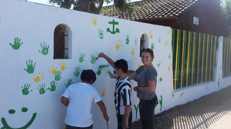 Zurzeit sind in Chile  Sommerferien. Marie Eckermann (r.) streicht mit den Kindern, die nicht nach Hause gefahren sind, Wände und Zäune des Heims. 