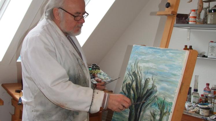Eckhard Bergmann in seinem Atelier. Hier legt er letzte Hand an das für die Ausstellung vorgesehene Bild „Weiden am Wasser“ an. 