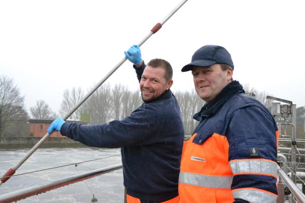 Vorarbeiter Mirko Klein und Anlagenbediener Maik Nehls (v.l.) messen den Schlammgehalt im Belebungsbecken mittels Schlammvolumen-Messung.  