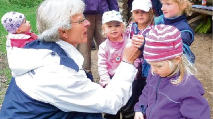 Durchblick: Der kleine Honke (6) zeigt Michael Sarach seine Lupe. Beim Besuch des Kindergartens erlebte der Ahrensburger Bürgermeister so einiges.  Foto: st