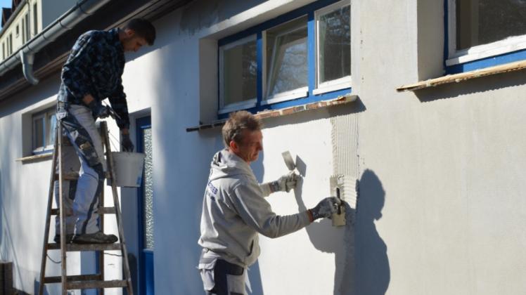 Mitarbeiter der Malerfirma Uwe Wohlfart bei der Neugestaltung der Außenfassade am Eingangsgebäude des Waldbades Grabow. 