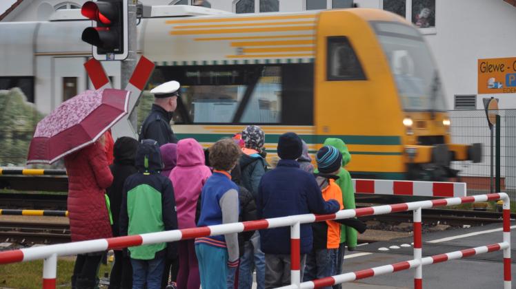 Am Bahnübergang Laascher Straße beobachten die Kinder hinter der Schranke einen vorbeifahrenden Zug. Fotos: andreas münchow 
