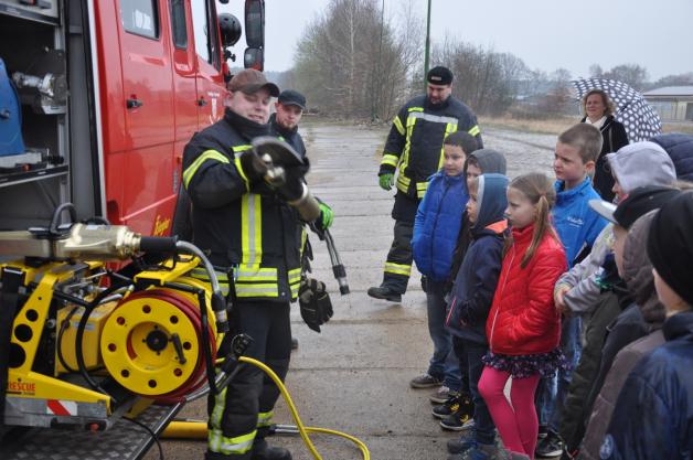 Feuerwehrmänner zeigen den Kindern ihre Technik.
