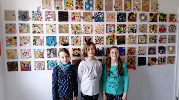 Farbenspiel: Melisse, Hannah und Amelie vor der Wand mit den bemalten Holzfliesen. Die sollen nun bei einer Auktion zum Schuljubiläum versteigert werden Fotos: privat 