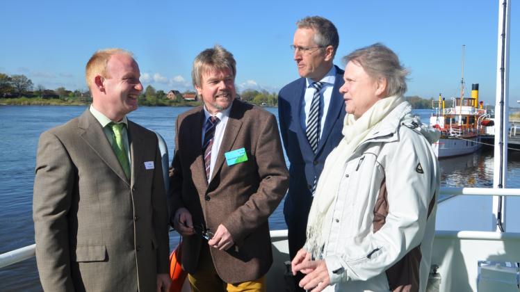Almut Kottwitz nimmt mit Rainer Karstens sowie Klaus-Jürge Steinhoff und Heiko Warnecke (v. r.) vom NLWKN die an diesem Tag friedliche Elbe auf Deck der „Lüneburger Heide“ in Augenschein.  