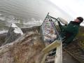 Ein Mitarbeiter des Nationalpark Jasmund stapelt Sandsäcke auf die Plattform an der Victoriasicht  