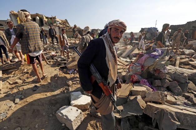 Ein Huthi-Rebell steht bewaffnet auf Trümmern - mutmaßlich wurden die Häuser durch einen Luftangriff der Saudis zerstört.