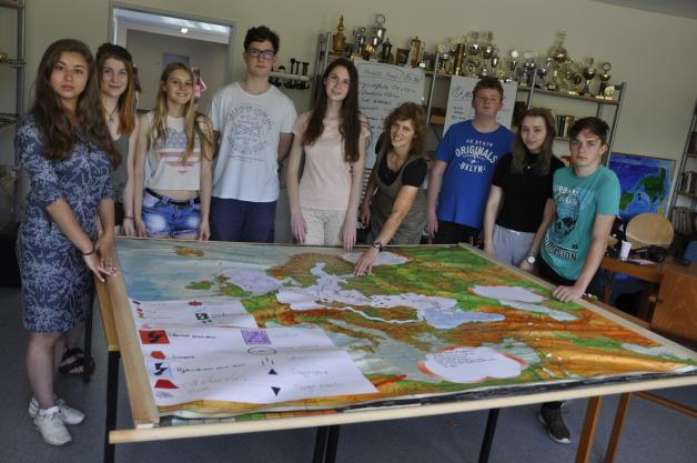 Die Geografie-Gruppe macht auf einer Landkarte auf die Verschmutzungsursachen aufmerksam.