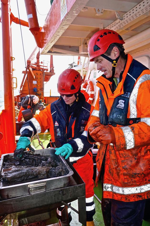 Eine Ladung Schlick, soeben im Mini-Bagger vom Meeresboden geholt. Teamleiter Rolf Lüchow und Annette Kramer (beide HPA) rühren noch einmal kräftig um, dann beginnt das Abfüllen in Gläser. Eine Ladung Schlick, soeben im Mini-Bagger vom Meeresboden geholt. Teamleiter Rolf Lüchow und Annette Kramer (beide HPA) rühren noch einmal kräftig um, dann beginnt das Abfüllen in Gläser.
