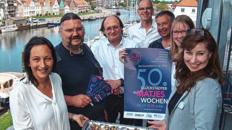 Freuen sichauf die 50. Glückstädter Matjeswochen (v.l.): Sandra Kirbis (Glückstadt Destination Management, GDM), Peter Schäfer (Reifendienst Schäfer/US-Cars und Oldtimer), Nils Gehrmann (Volksbank Pinneberg-Elmshorn), Moderator Stefan Wolter, Gerd Burkhardt (Stadtwerke Glückstadt), Ann-Kathrin Witzdam (GDM) und Bürgermeisterin Manja Biel. 