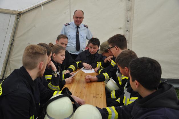 Amtswehrführer Toralf Pfohl (m.) und Wehrführer Ronny Kubat (l. daneben) mit der jungen Feuerwehr-Crew aus Besitz beim Fragekomplex.