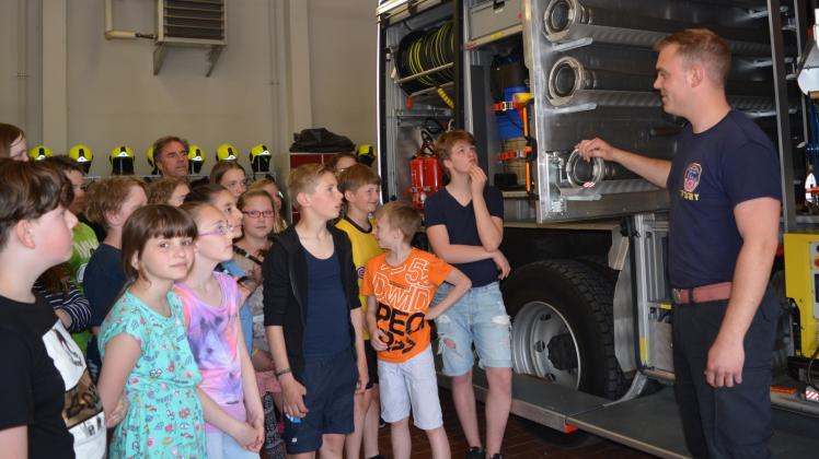 Jugendwart Stefan Gehlhaar erläutert den Schülern mit welchen Gerätschaften ein Feuerwehrfahrzeug ausgestattet ist. 