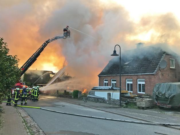 Die Feuerwehr löscht die brennenden Gebäude.