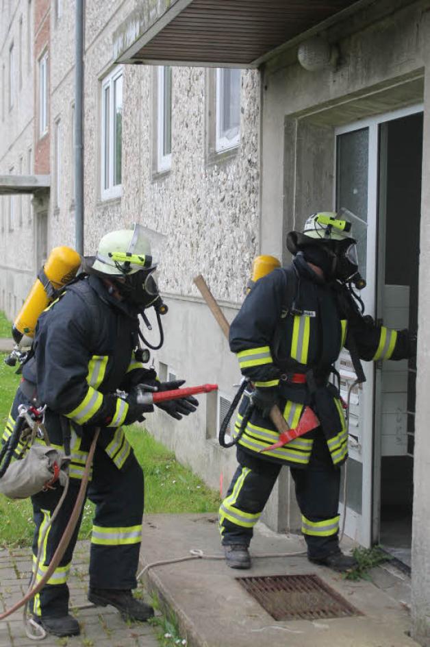 Atemschutzträger gehen bei einer Alarmübung in eine verräucherte Wohnung. Atemschutzträger gehen bei einer Alarmübung in eine verräucherte Wohnung.