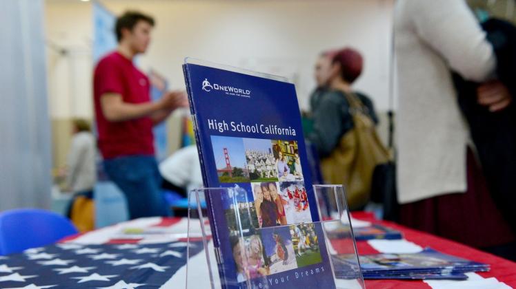 besucher  informieren sich auf einer Schüleraustausch-Messe über einen Aufenthalt in den USA.  