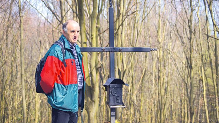 Der Wanderer und Buchautor Waldemar Siering neben dem Gipfelkreuz auf dem Helpter Berg bei Helpt 