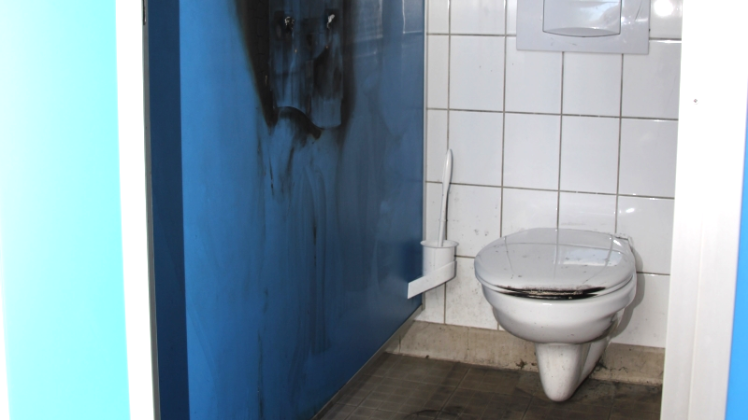 An der linken Wand stand der Toilettenpapierspender in Flammen. 