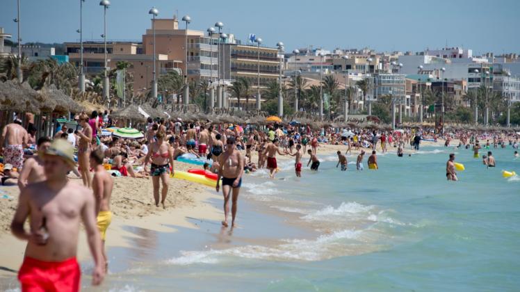 Urlauber tummeln sich am Strand von Arenal auf Mallorca.  