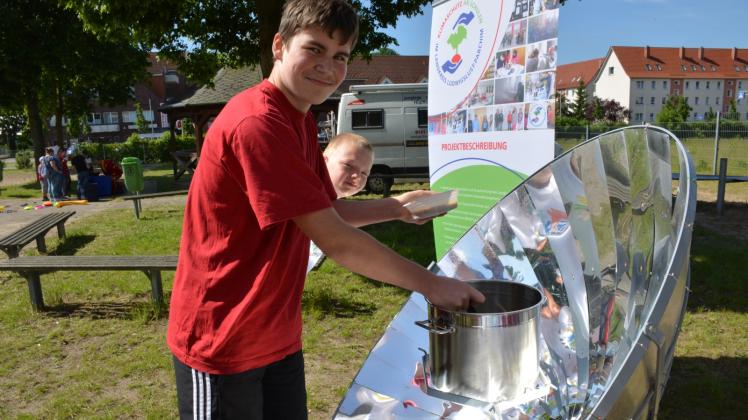 Philipp erhitzt mit Hilfe eines Parabolspiegels beim Familientag an der Förderschule Ludwigslust den Erbseneintopf.  Fotos: M. Seifert 