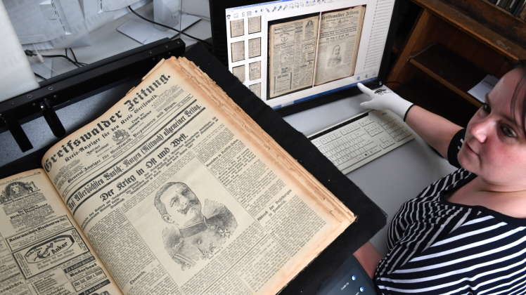 Bibliotheksmitarbeiterin Jana Passehl digitalisiert in der Univ-Bibliothek Greifswald eine Zeitung aus dem Jahr 1914 mit einem Scanner. Die Digitale Bibliothek ist offiziell freigeschaltet.  Fotos: Stefan Sauer 