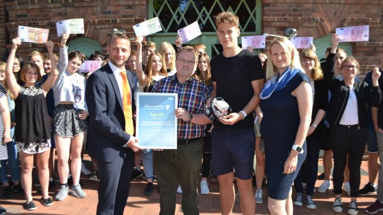 Im Beisein der Schüler überreichten Martin Steuber (VR-Bank eG Wismar, l.) und Annika Lichtenauer (easyCredit, r.) die Auszeichnung an Lehrer Frank Langpap und Schüler Georg Weber 