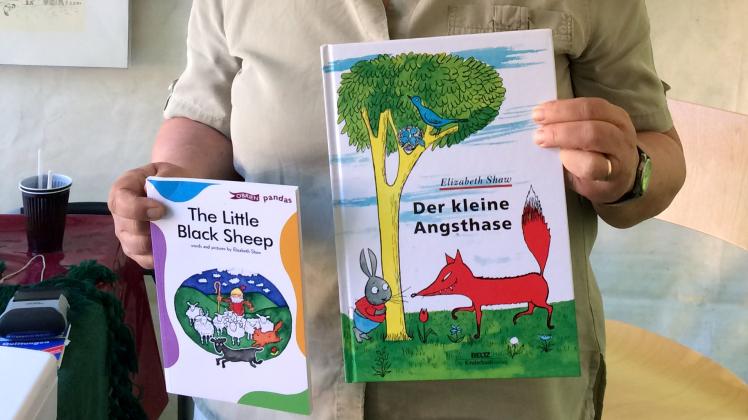 Anne Schneider, Tochter der DDR-Kinderbuchautorin und Illustratorin Elizabeth Shaw (1920-1992), hält zwei Bücher ihrer Mutter in die Höhe.
