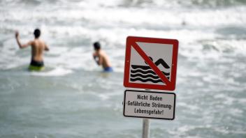 Leichtsinn am Ostseestrand: Ein Schild warnt die Besucher vor starker Strömung. Nicht alle halten sich an das Badeverbot.