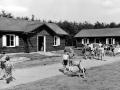 Zur Einweihung des Kinderferiendorfes entstand 1961 dieses Foto. Kinder toben zwischen den einfachen Hütten herum. 