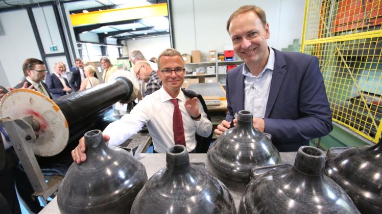Steffen Mirtschin, Geschäftsführer der Hermann Römmler Kunststofftechnik GmbH, zeigt Wirtschaftsminister Albrecht Gerber die Lagerdorne für Drehgestelle von Zügen.  
