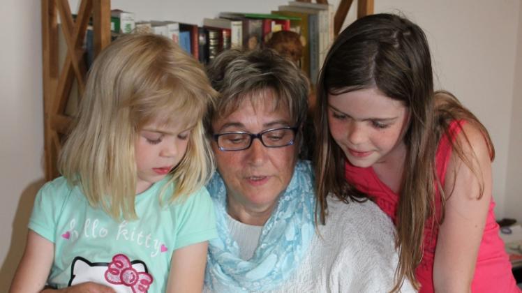 Mit ihren Enkelinnen Betty (l.) und Isabelle liest Annette Hacke gern in alten Märchenbüchern.  
