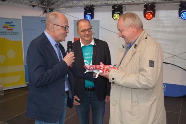 Güstrows 1. Stadtrat Andreas Brunotte (l.) und Andreas Bluhm (M.) übergaben den Staffelstab an Frank Ilchmann, Bürgermeister von Ribnitz-Damgarten, wo die nächsten Seniorensportspiele stattfinden. 
