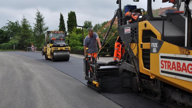 Mit Maßarbeit wird die Asphaltdecke eingebaut. Die Binderschicht darunter war in der Woche erneuert worden.  Fotos: Rüdiger Rump 
