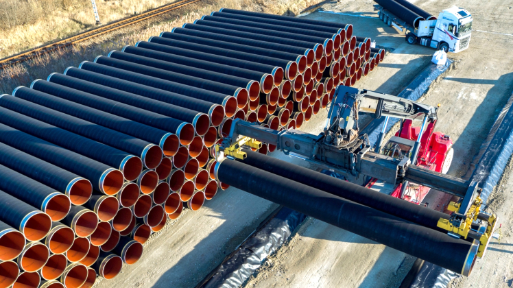 Mit Hilfe eines Spezialkrans werden die tonnenschweren Rohre für die zukünftige Ostsee-Erdgastrasse Nord Stream 2 im Hafen von Sassnitz auf einen Lagerplatz transportiert.  
