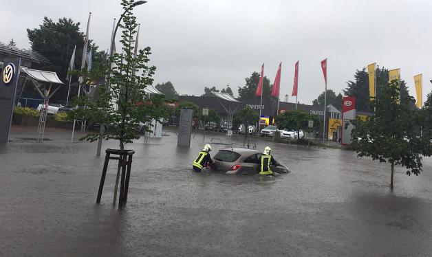 Feuerwehrleute bergen gestern  in Oranienburg ein liegen gebliebenes Fahrzeug von einer überfluteten Straße.