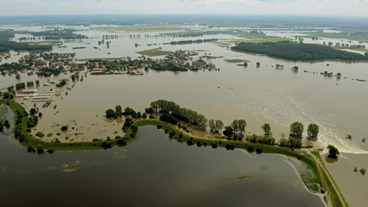 Ein Deichbruch (unten rechts) überflutet das Dorf Fischbeck in Sachsen-Anhalt. DieBundesländer kämpfen mit Millionen gegen die Hochwassergefahr.  