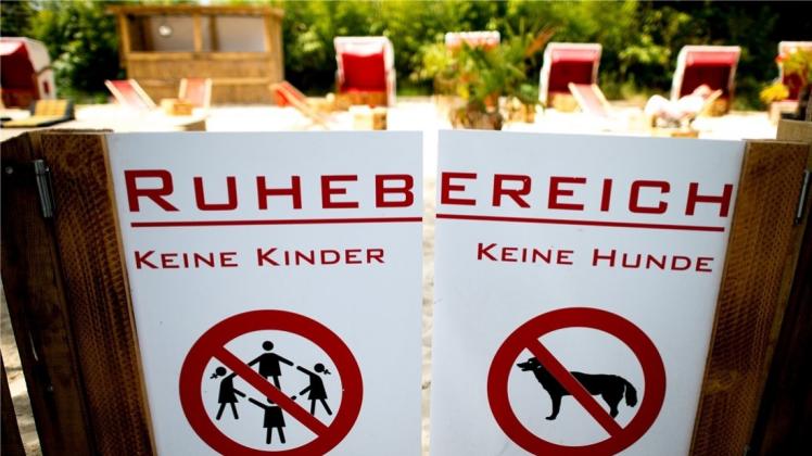 Verbotsschilder für Kinder und Hunde an einer Tür zum Ruhebereich eines Biergartens. Mit einer kinderfreien Zone hat sich ein Biergarten-Betreiber in Düsseldorf Ärger vor allem mit Müttern eingehandelt. Auch kinderfreie Hotels sind umstritten. 