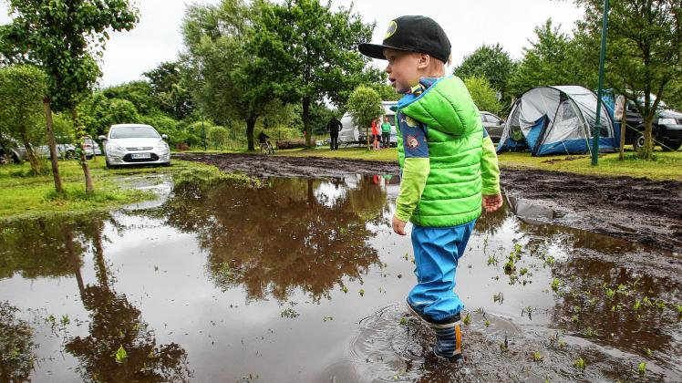 Spaß trotz Regen: Der drei Jahre alte Oskar aus Berlin spielt auf dem Campingplatz in Hohenkirchen (Landkreis Nordwestmecklenburg). 