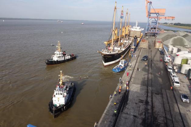 Schlepper ziehen die „Peking“ aus dem Dockschiff.
