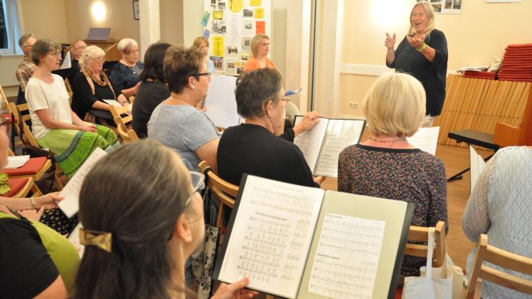 Mit dem Liederbuch in der Hand verfolgen die unterschiedlichen Teilnehmer aufmerksam, welche Töne Chorleiterin Inge Lass-Adelmann (hinten rechts) vorgibt.  