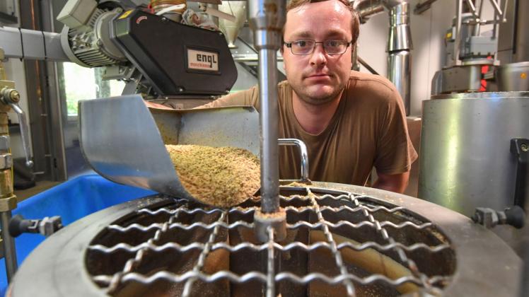 Der Mitarbeiter Chris Muchan von der Kanow-Mühle bei Golßen füllt Leinsamenschrot in eine Form für die Ölpresse.  