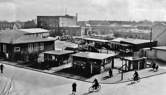 Auf dem Gelände Christianstraße/Berliner Platz wächst die 1947 in Neumünster gegründete AEG Schaltgeräte-Fabrik. An der Straßenecke gab es jahrelang einen Kiosk.