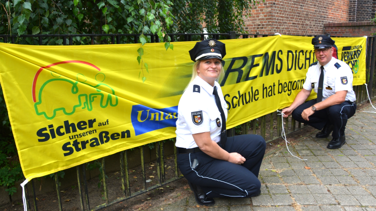 Carola Johannsen und Karsten Hamann, Präventionsbeamte der Polizeiinspektion Güstrow, hängten gestern ein gelbes Banner vor der Güstrower Fritz-Reuter-Schule auf.  