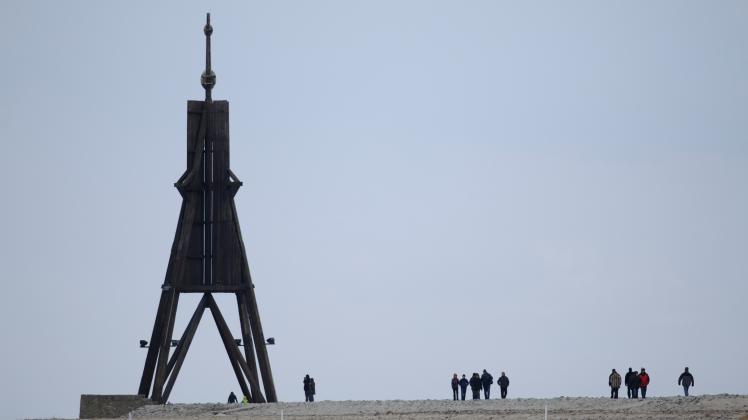 Spaziergänger sind am Strand von Döse in Cuxhaven am historischen Seezeichen „Kugelbake“ an der Elbmündung unterwegs. Symbolbild